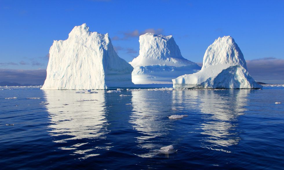 Three icebergs in middle of the ocean