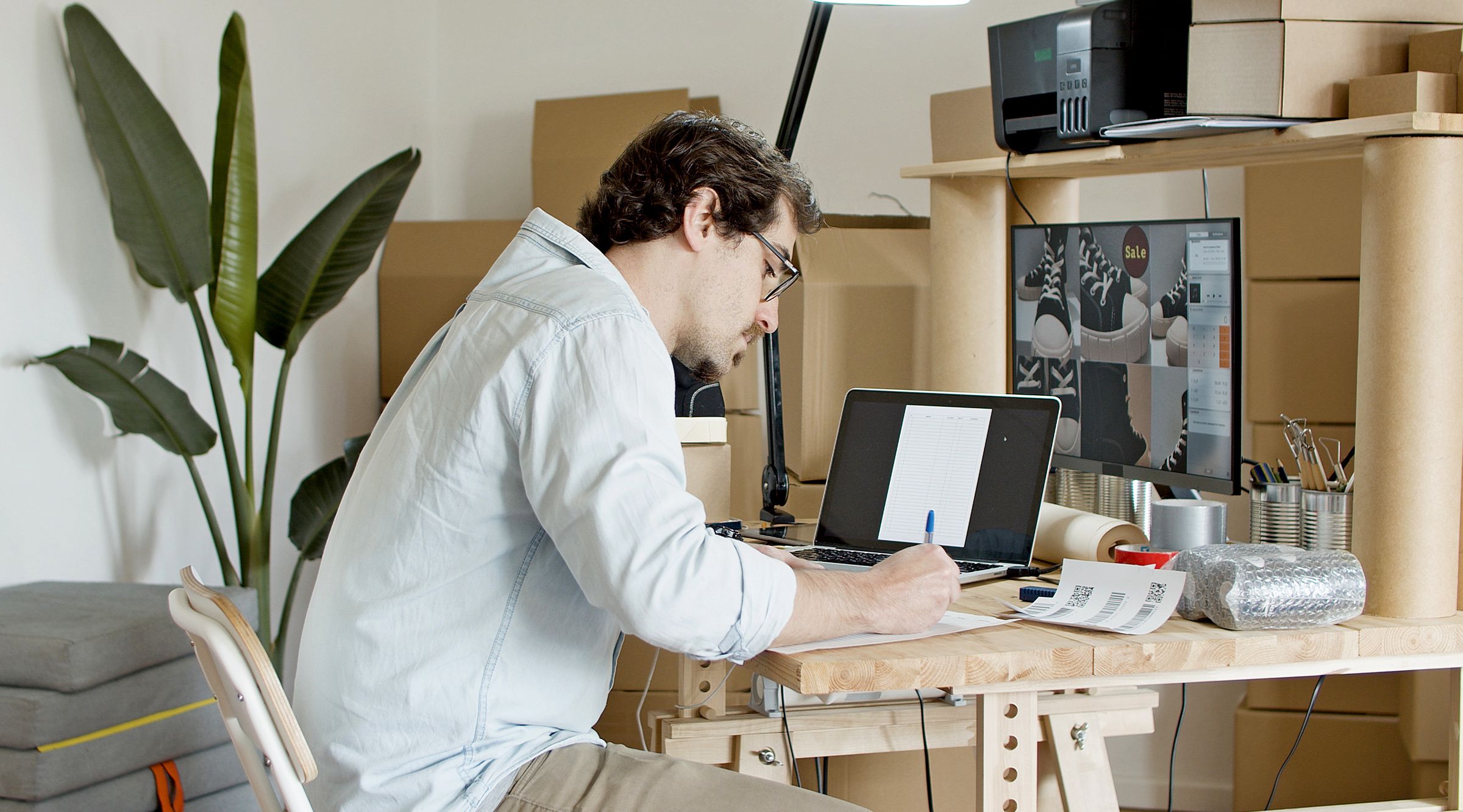Man writing down calculations for his online business