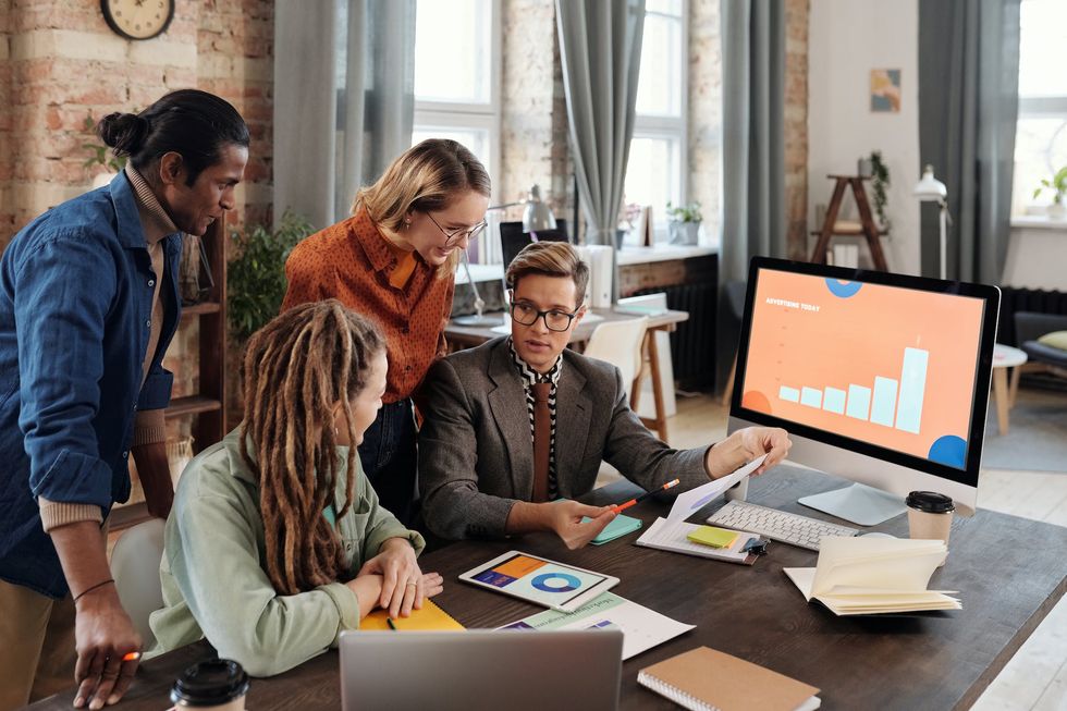 People gathered around a desk looking at a report