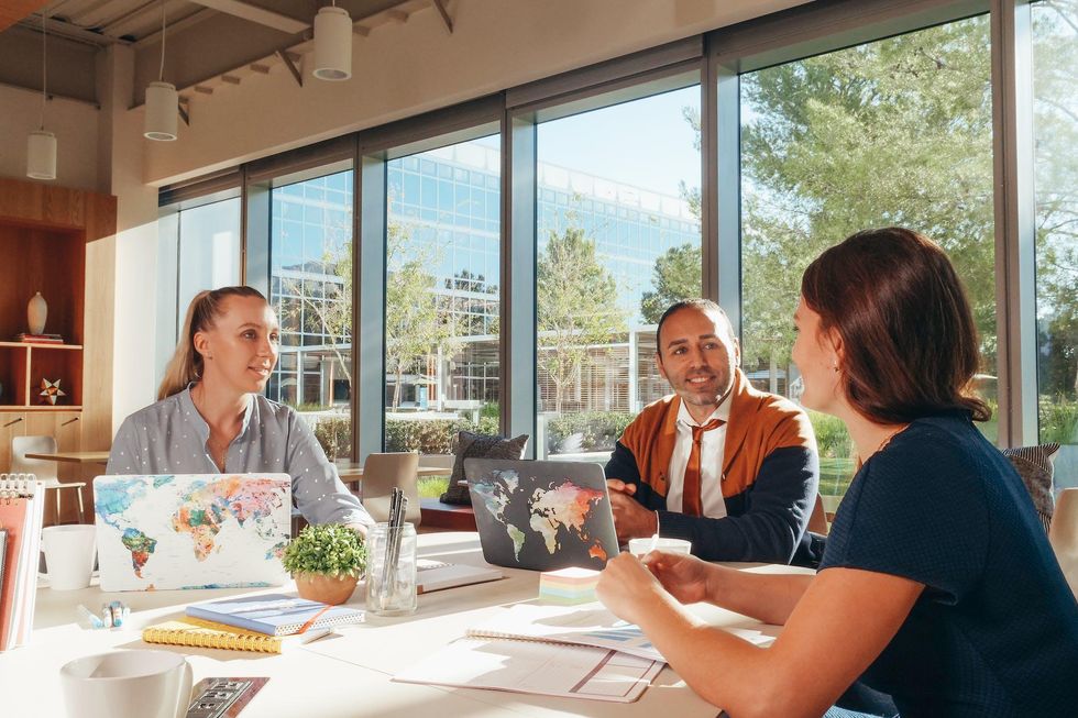 People sitting around a table with theire laptops